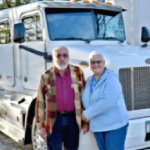 old couple standing in front of truck